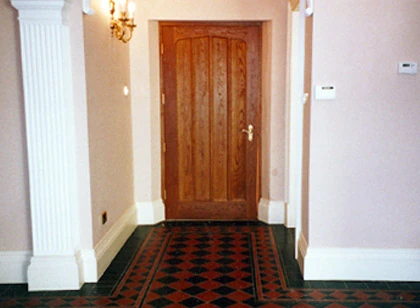A panelled timber door in a traditional hallway.