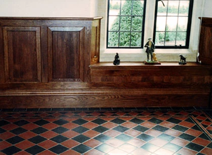 Timber panelling beneath a leaded window.