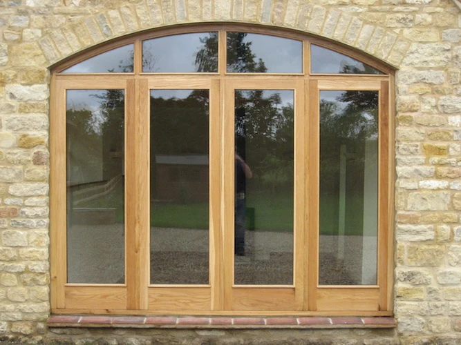 Timber frames set into a stone elevation.